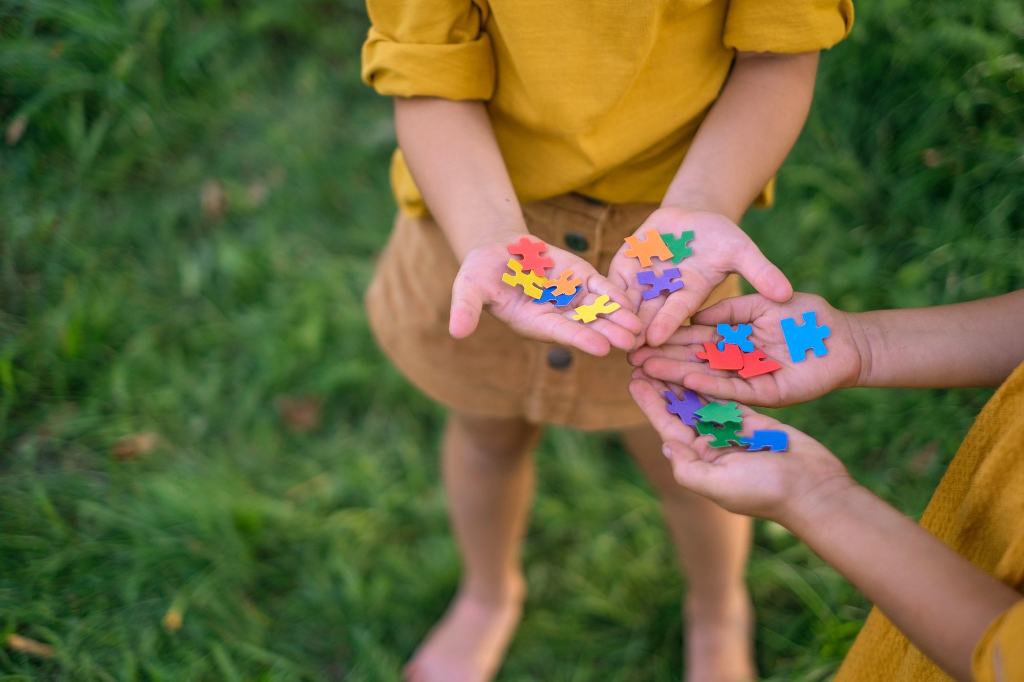 Children hold pieces of puzzles in palms as sign of support and solidarity with people with autism